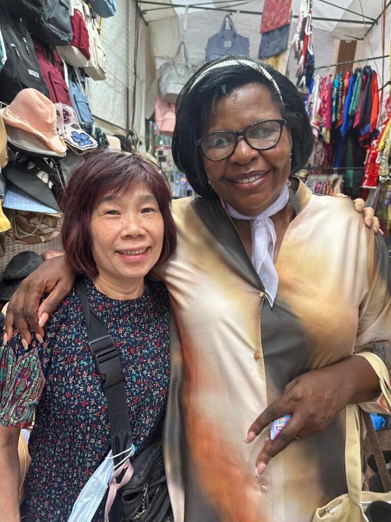 A TCI minister with a friend at a market during the Great Commission Global Tour