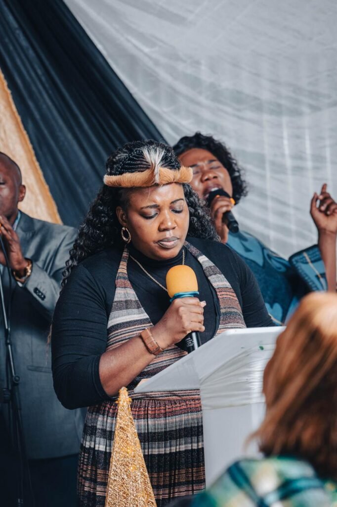 A woman leading prayer at the TCI pulpit