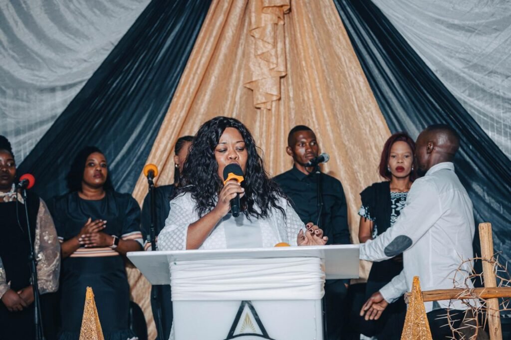 A woman ministering at the pulpit with the congregation behind her