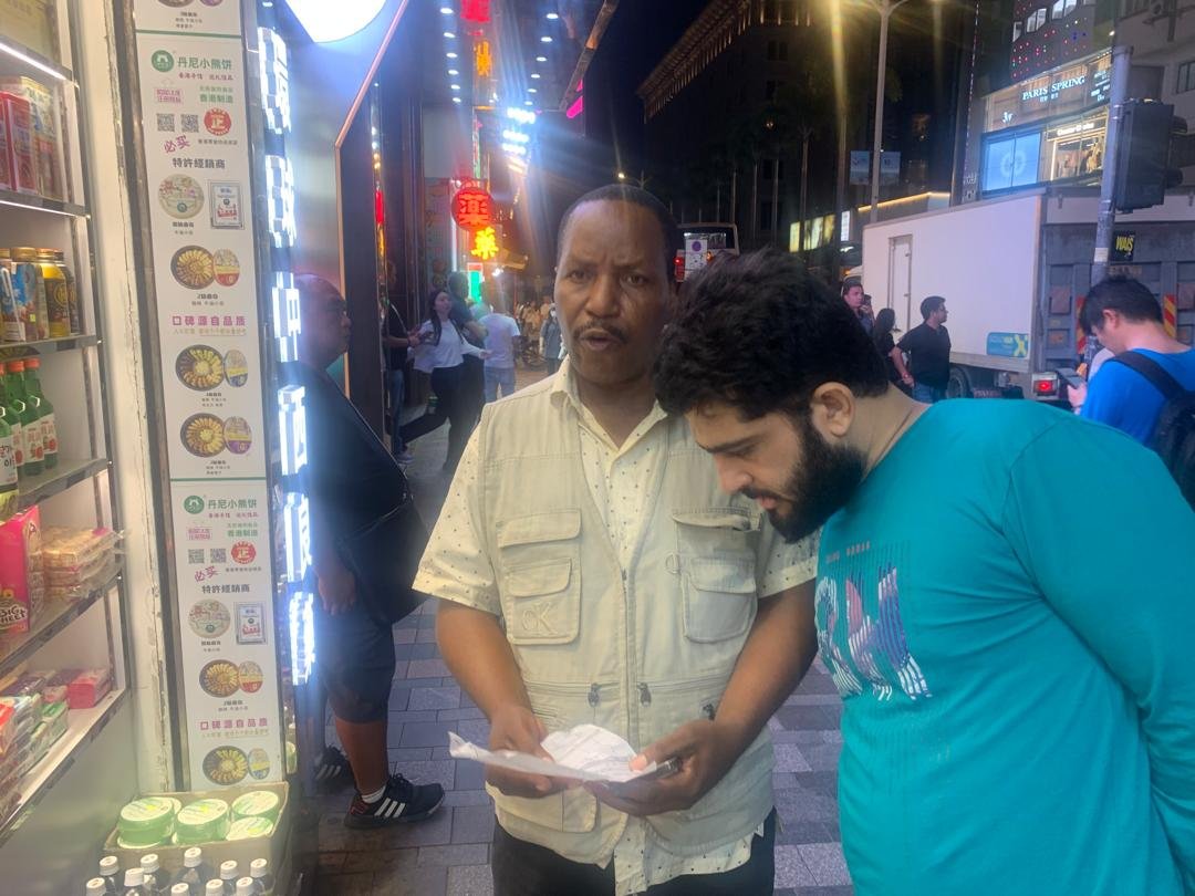 A TCI member witnessing to a man on a busy city street at night